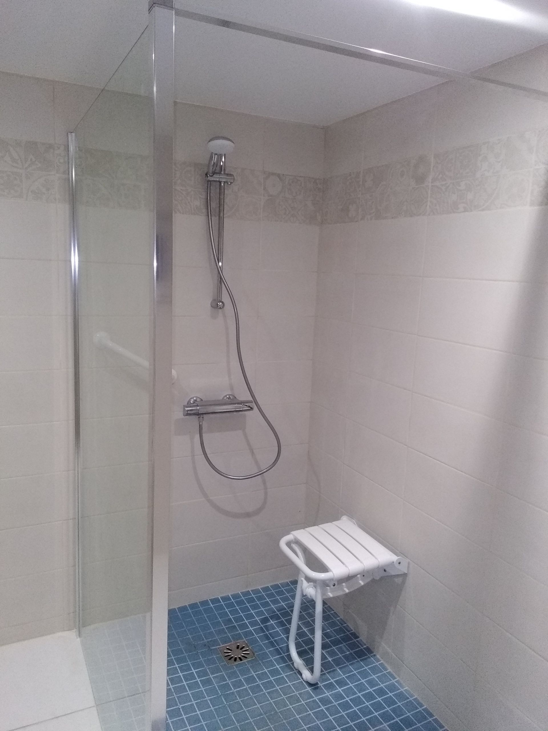 Focus sur une douche adaptée aux personnes handicapées et à mobilité réduite spacieuse et siège