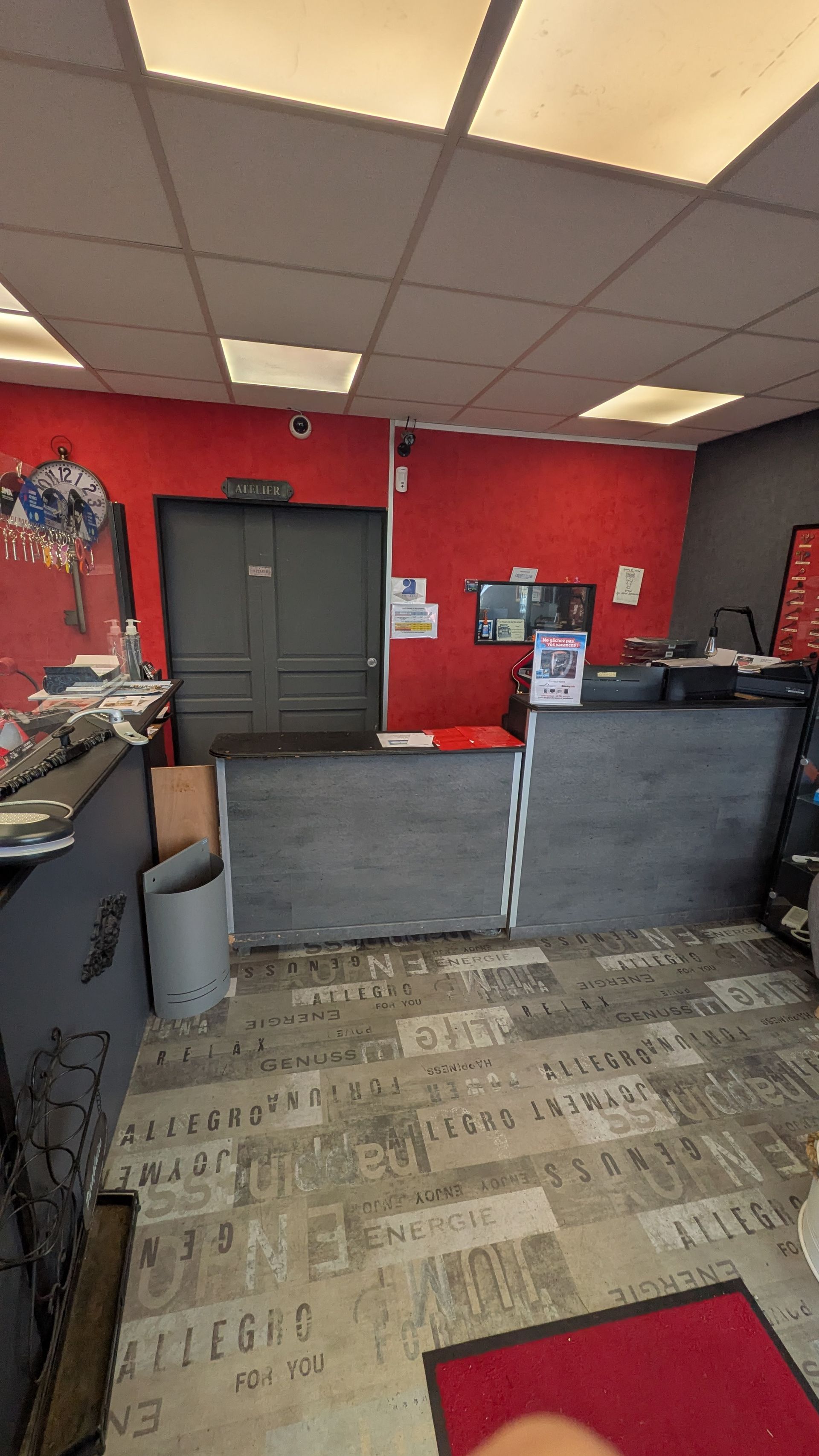 Hall d'accueil du magasin avec un mur rouge au fond