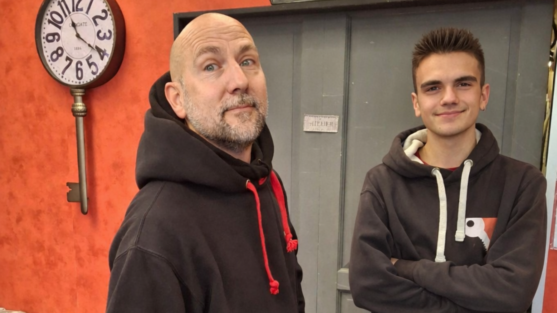 Deux personnes en tenue de travail debout dans un atelier