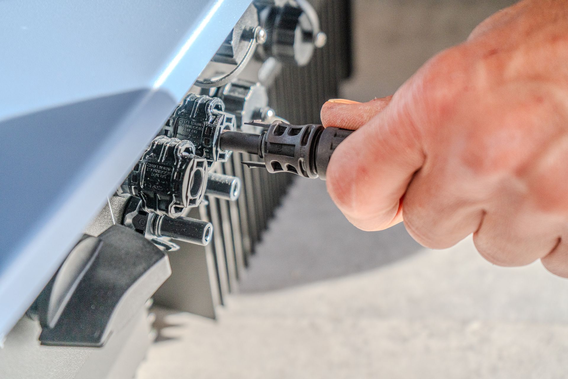 Deux collaborateurs de l'Atelier du Solaire se tiennent près d'une camionnette. L'un porte un sweat à capuche bleu, l'autre un gilet. La camionnette arbore des inscriptions jaunes « L'Atelier photovoltaïque ».