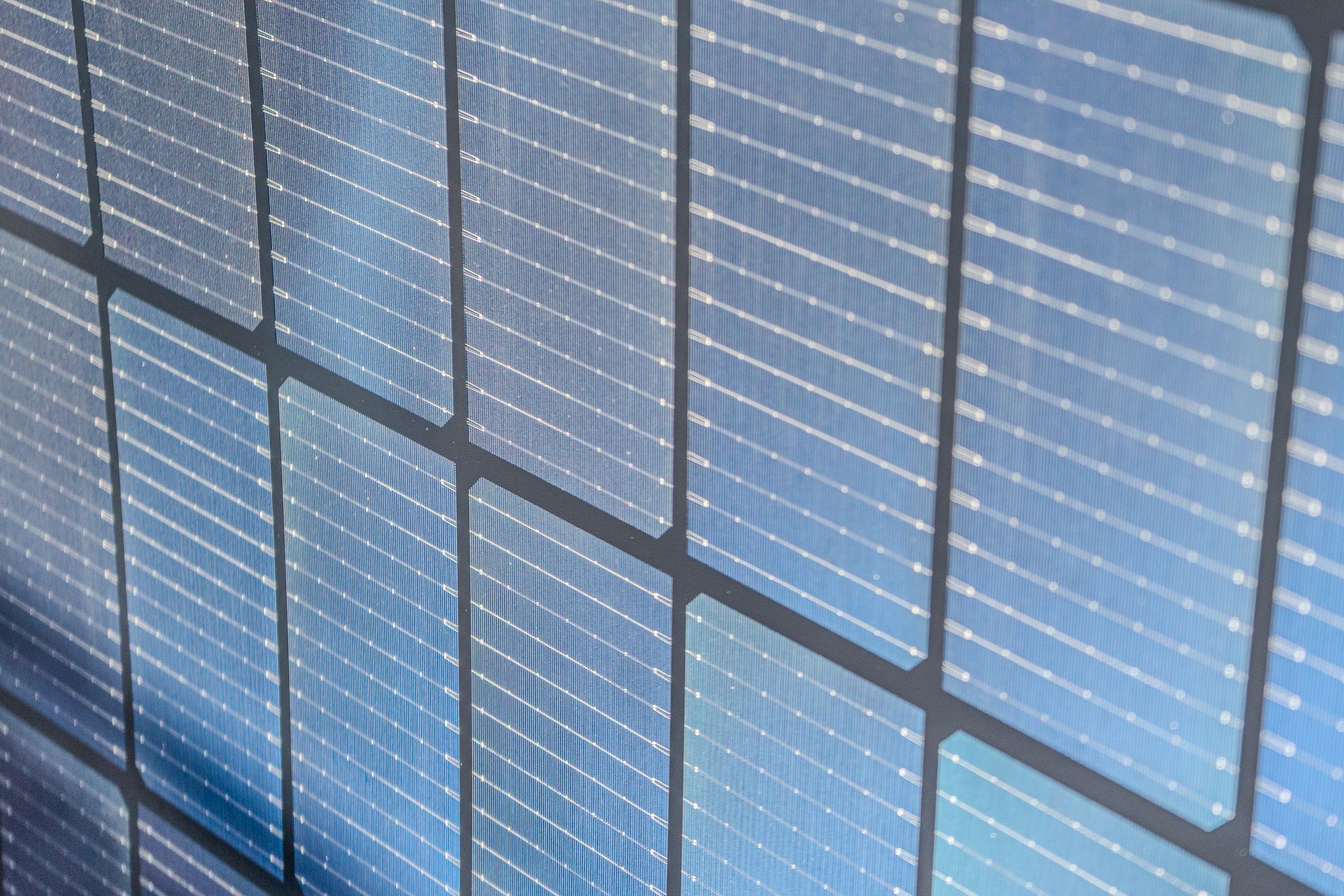 Panneaux solaires, gros plan, en perspective, montrant le reflet du ciel bleu.