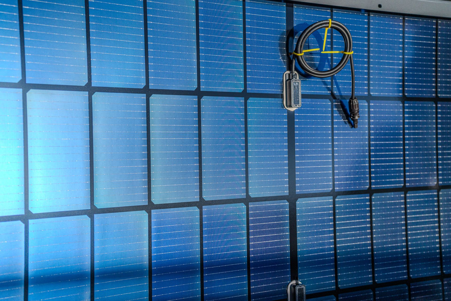 Panneaux solaires bleus avec lignes de grille noires ; équipement fixé à droite.