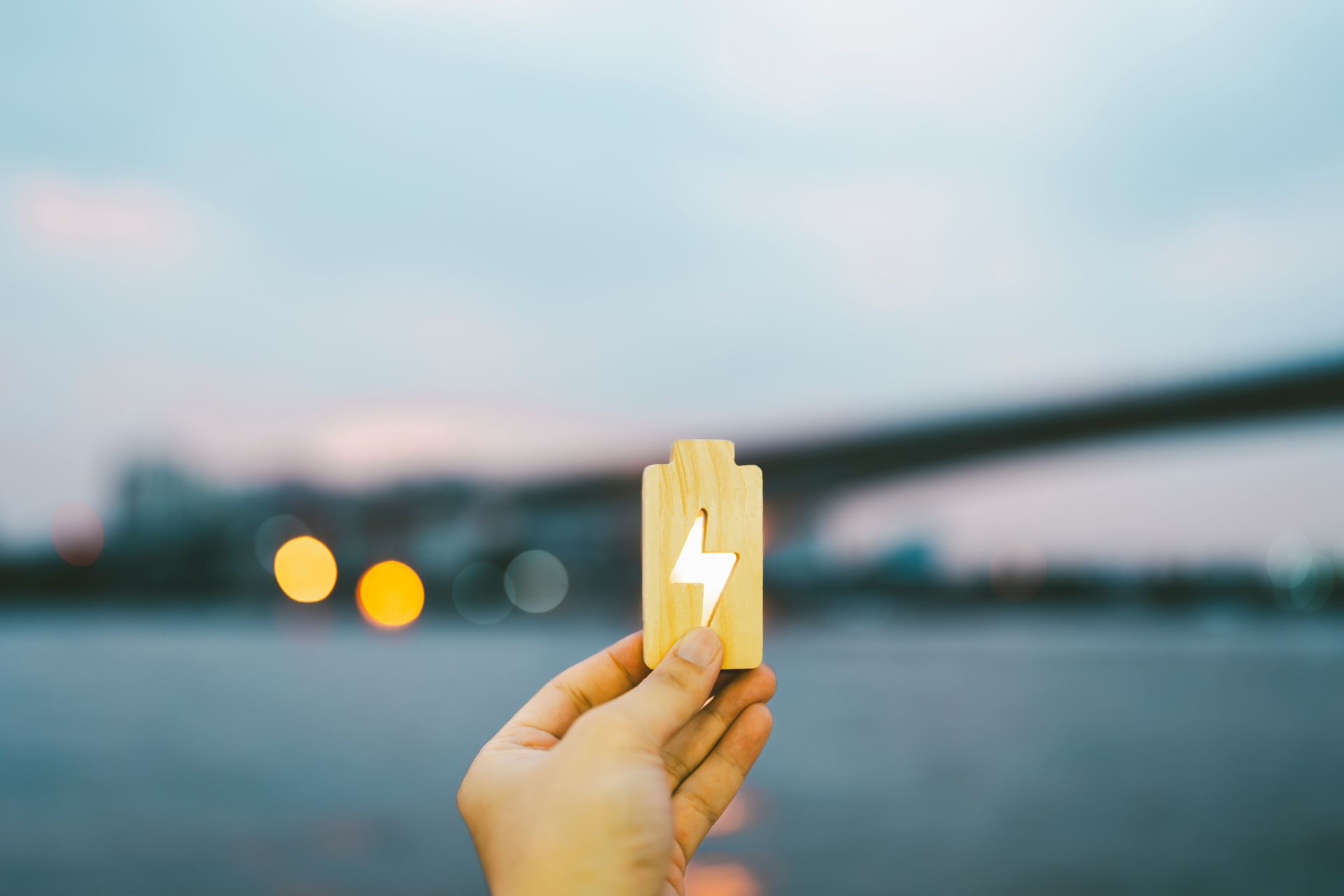 Petit symbole de batterie en bois tenu par quelqu'un