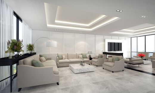 Un salon moderne et lumineux avec des canapés beiges, une table basse en marbre blanc, un sol carrelé gris et des plafonds à caissons.