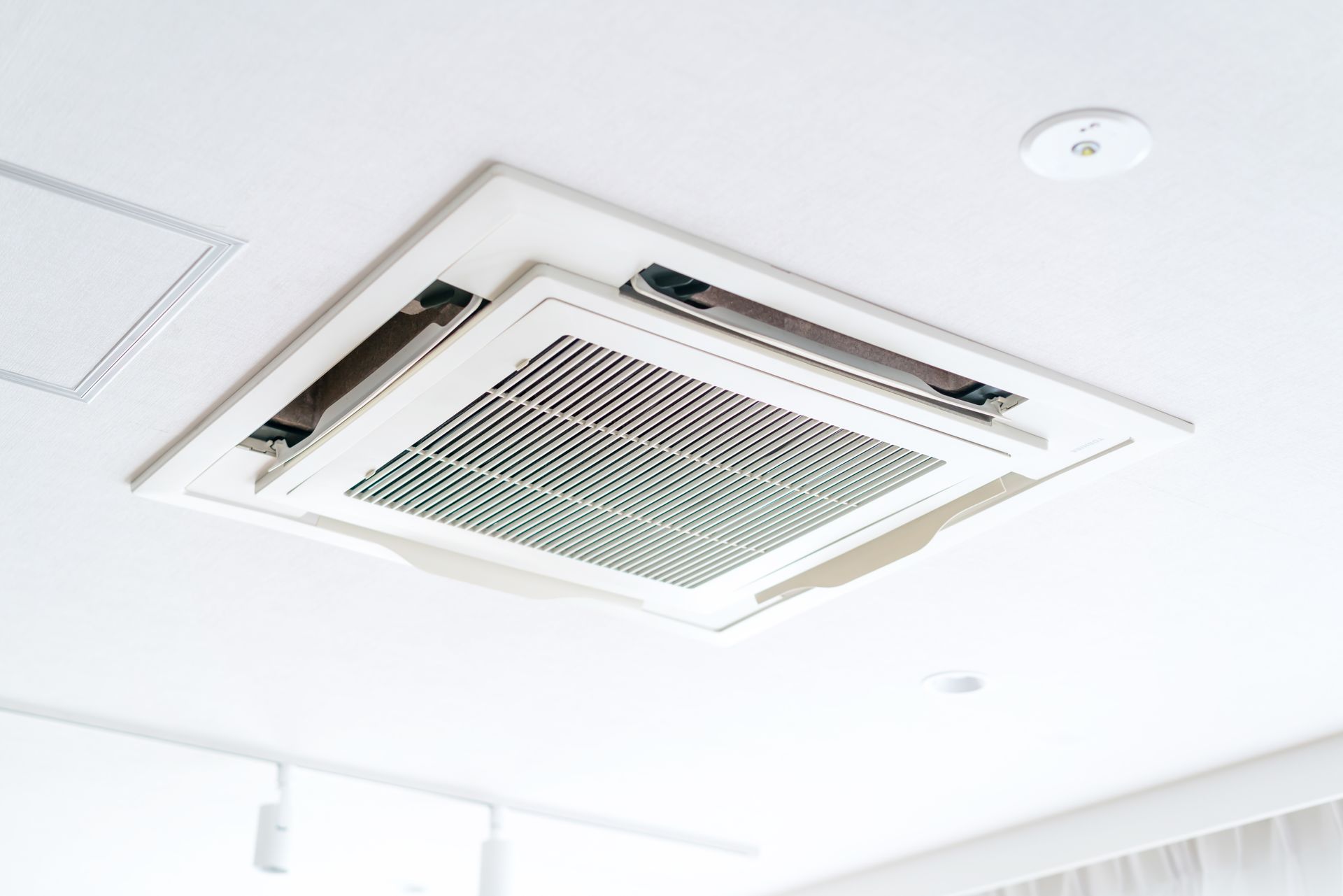 Un climatiseur blanc fixé au plafond.