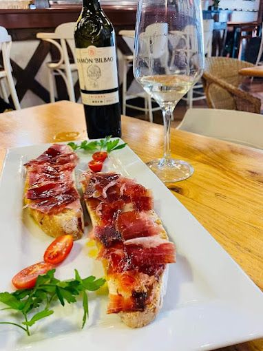 Un plato de comida con una botella de vino y una copa de vino en una mesa.