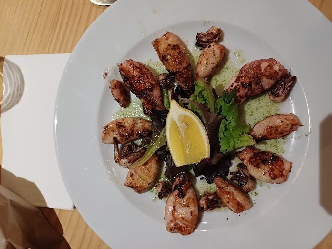 Un plato de comida con una rodaja de limón encima.