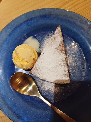 Un plato azul cubierto con una rebanada de pastel y helado.