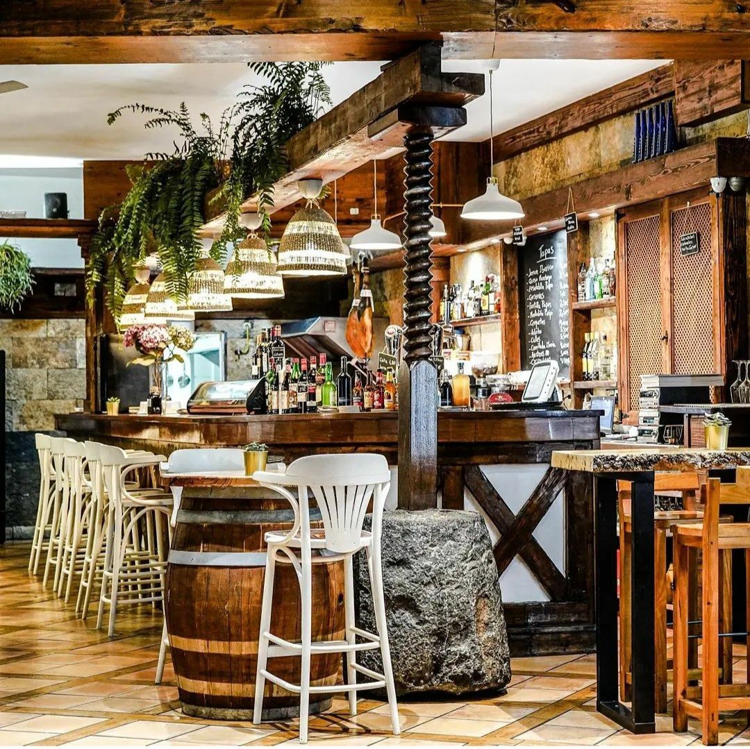 Un restaurante con un barril de madera en el medio de la habitación.