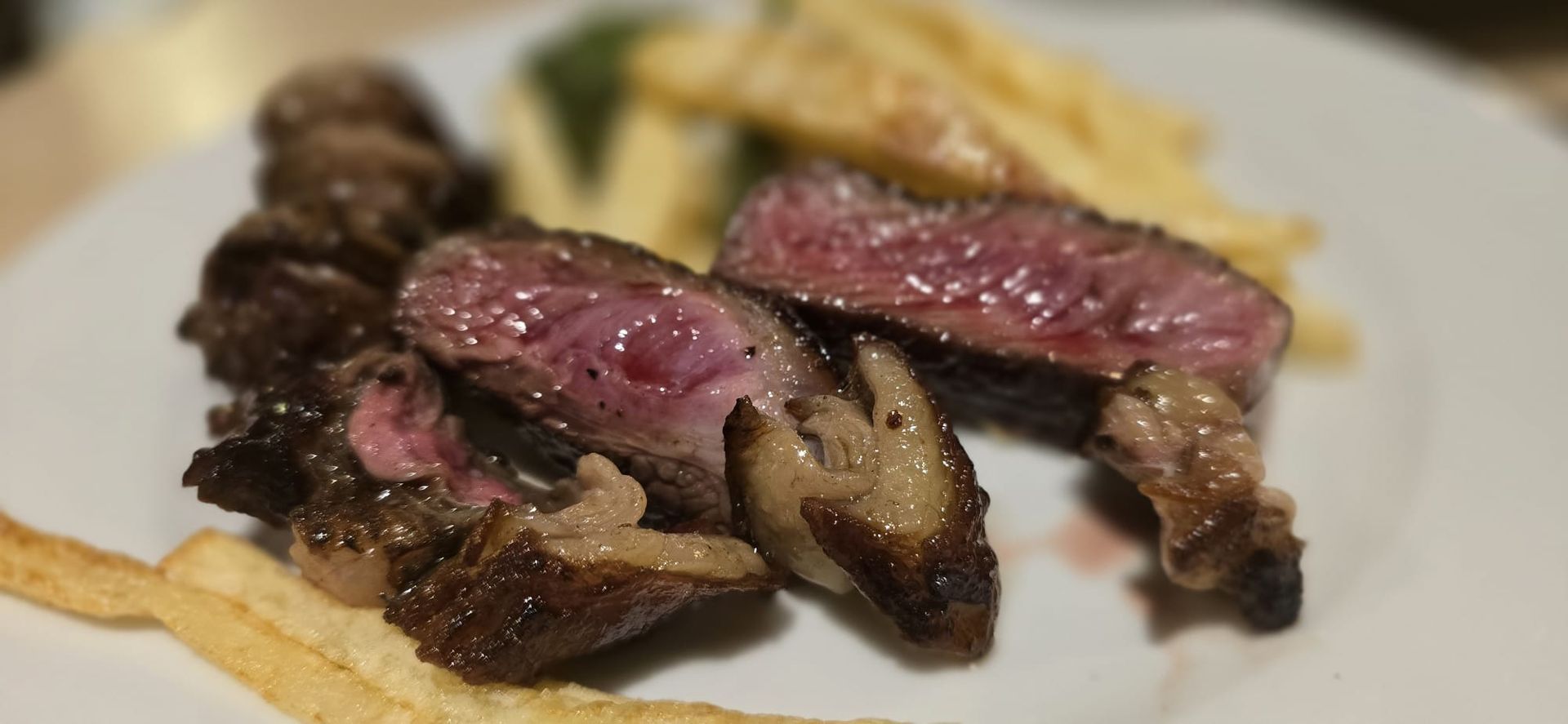 Un plato blanco cubierto con bistec y papas fritas