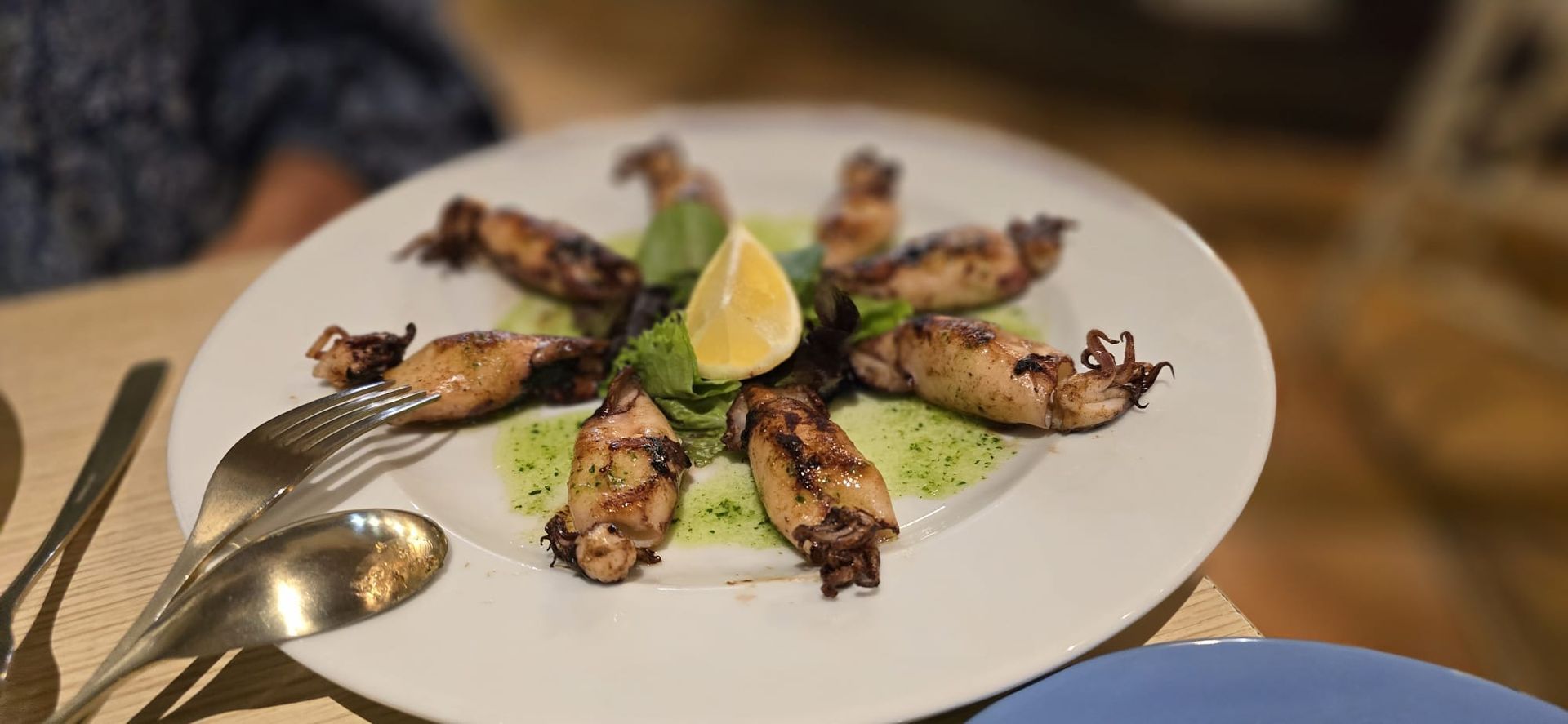 Un primer plano de un plato de comida sobre una mesa con utensilios.