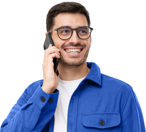 Un homme à lunettes, souriant au téléphone, porte une chemise bleue.