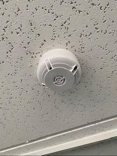 Un detector de humo está montado en el techo de un edificio.