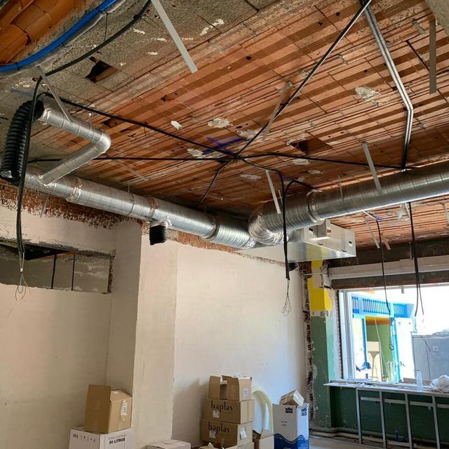 Una habitación con techo de madera y cajas en el suelo.