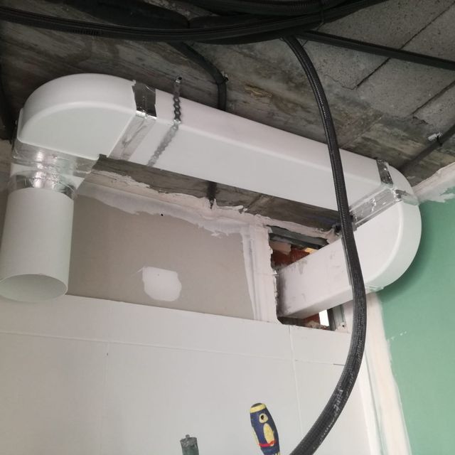 Un tubo blanco cuelga del techo junto a un destornillador.