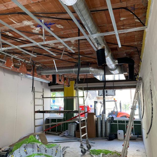 Una habitación que está siendo remodelada con una escalera colgando del techo.