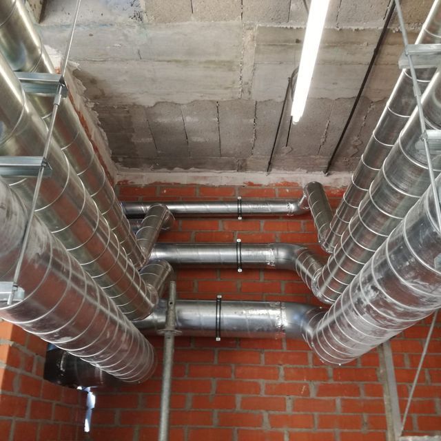 Una habitación con muchos tubos de metal colgando del techo.