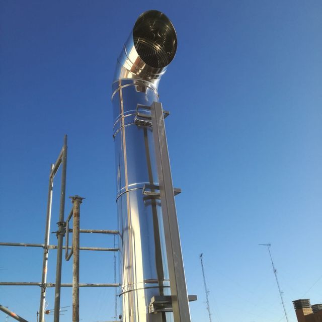 Un gran tubo de metal con un cielo azul de fondo.