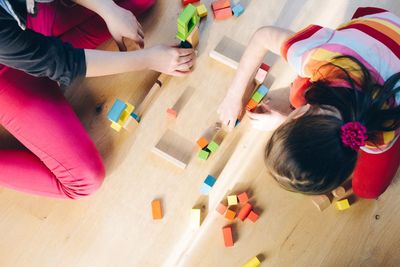 Un grupo de niños está jugando con bloques de madera en el suelo.