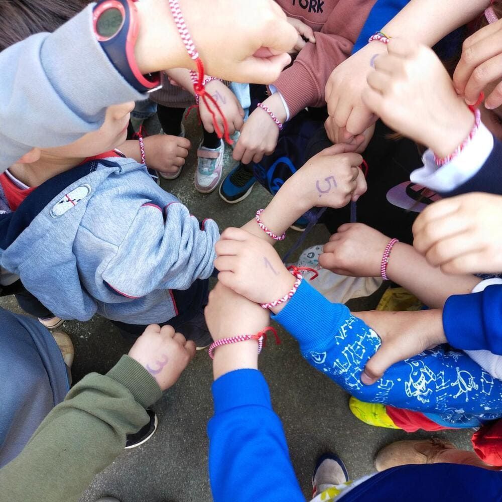 Un grupo de niños junta sus manos en un círculo.