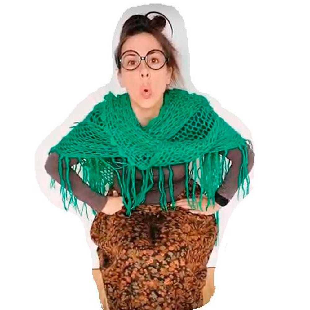 Una mujer que lleva gafas y una bufanda verde sostiene un pastel.