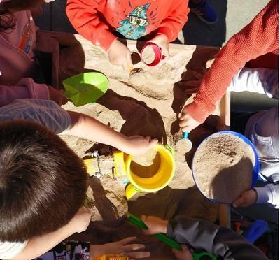 Un grupo de niños está jugando en un arenero.