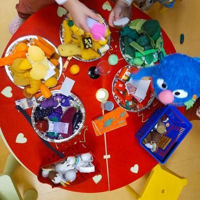 Un niño está jugando con comida en una mesa roja.