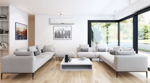 Salon moderne et lumineux avec canapés beiges, table basse blanche et grandes fenêtres à cadre noir.