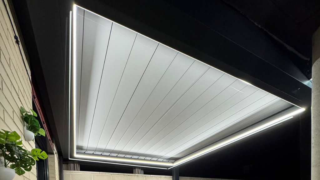 Toldo moderno para patio con iluminación LED brillante sobre un espacio exterior oscuro.