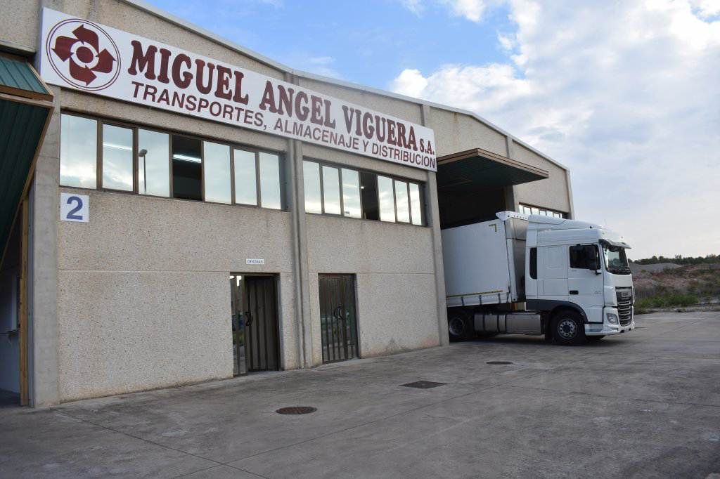 Un camión está estacionado frente a un edificio que dice Miguel Ángel Viguera.