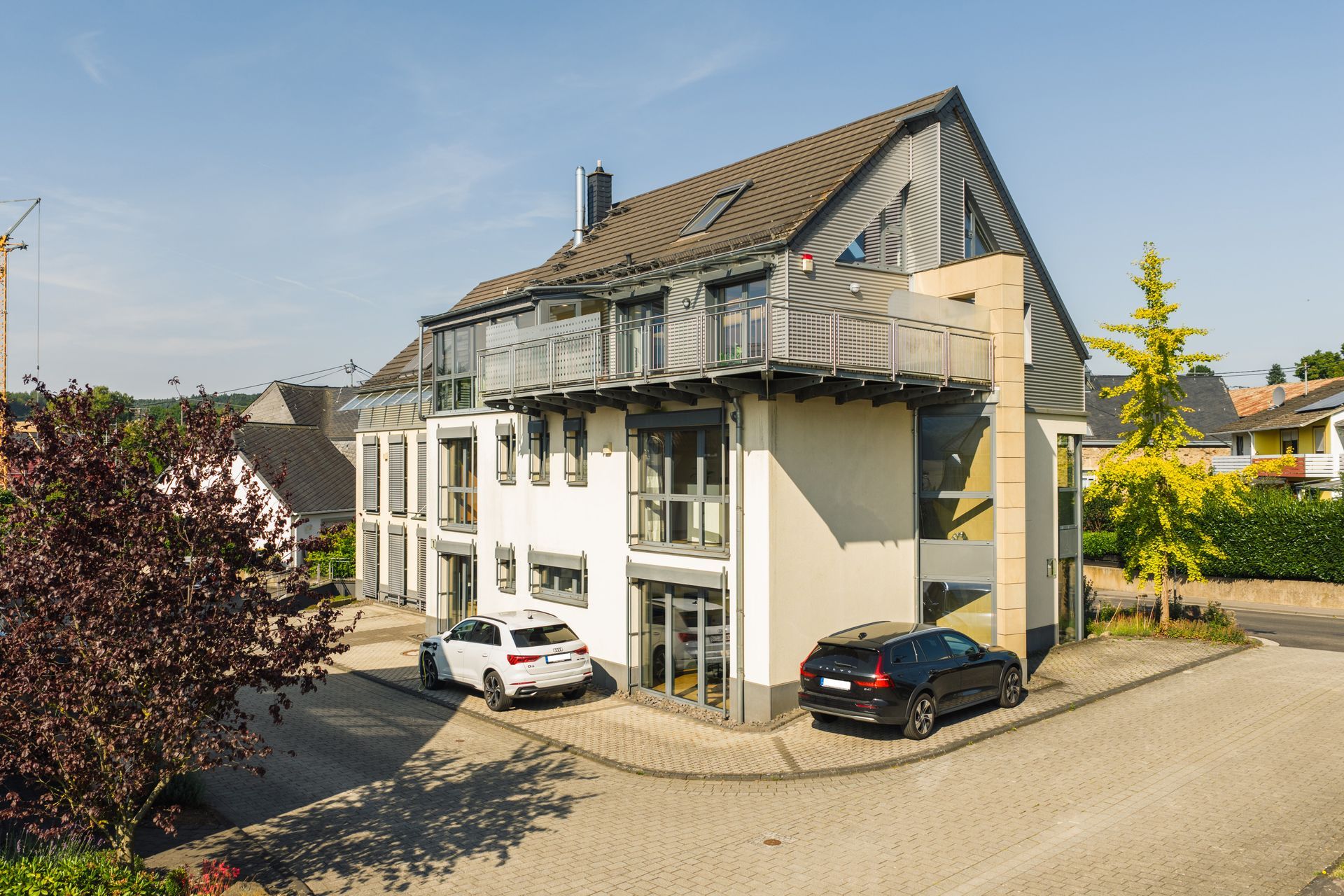 Außenansicht eines modernen Kanzleigebäudes mit Parkplätzen davor.