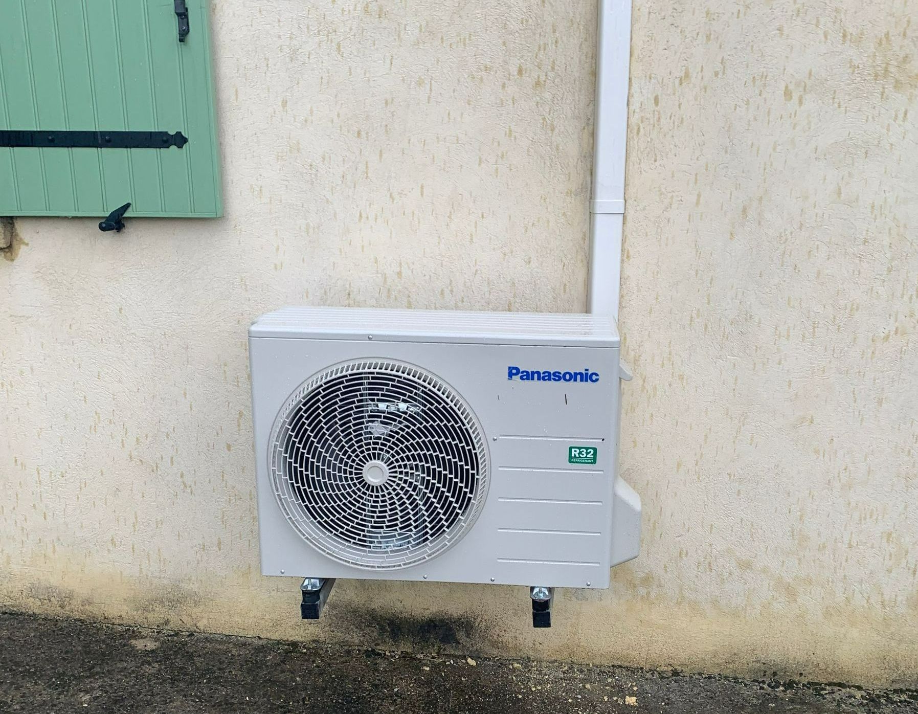 Une maison avec un volet vert
