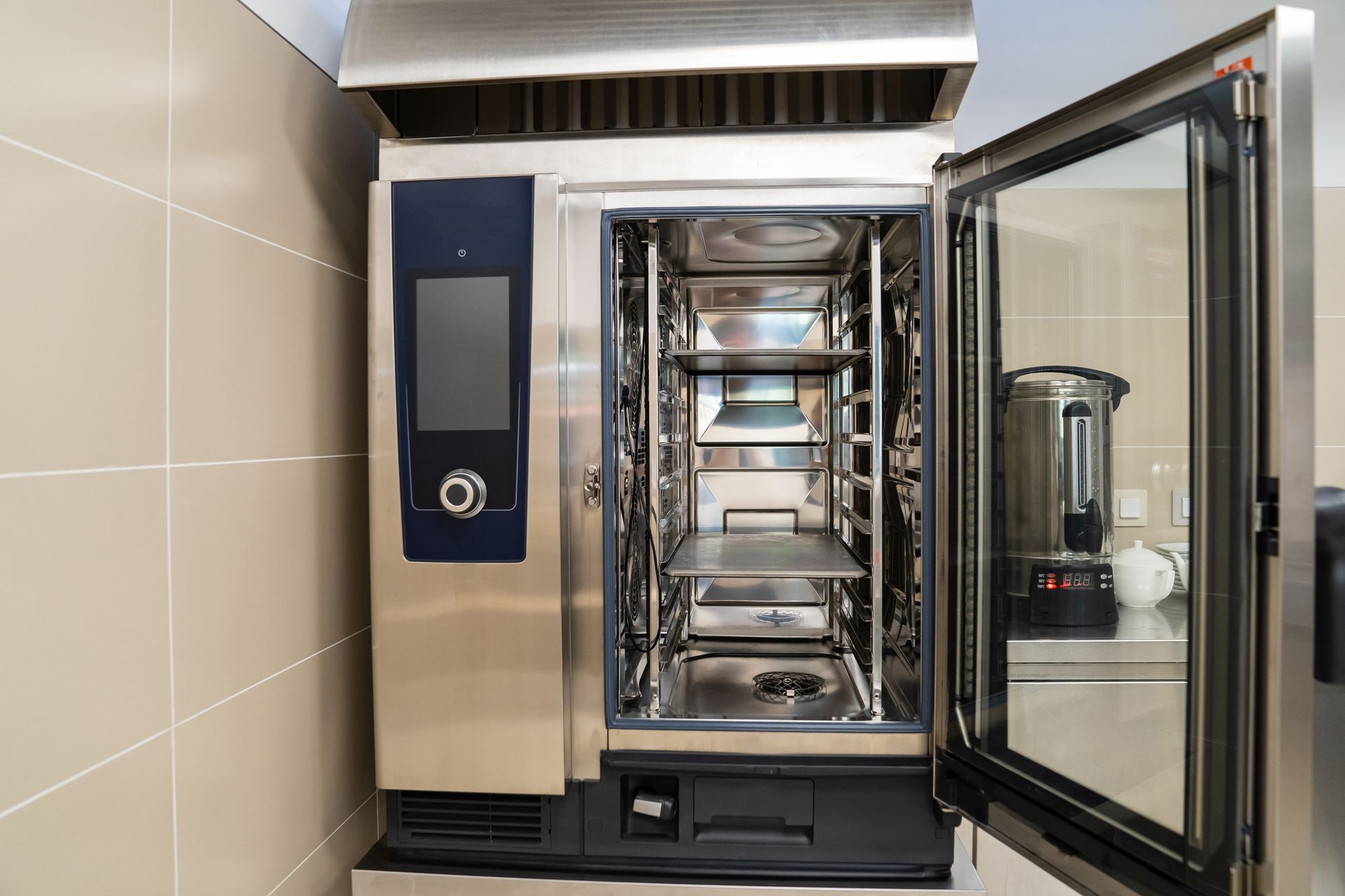 Four mixte ouvert avec plaques à l'intérieur et porte vitrée dans une cuisine professionnelle.