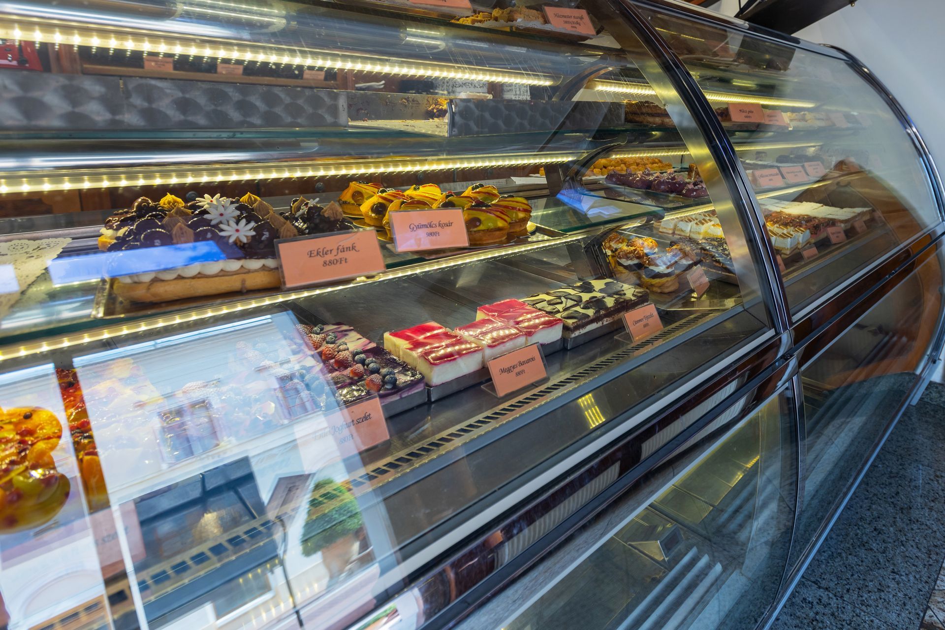 Vitrine de boulangerie présentant un assortiment de pâtisseries et de desserts derrière un verre