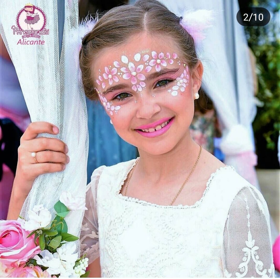 Una niña con flores rosas pintadas en la cara
