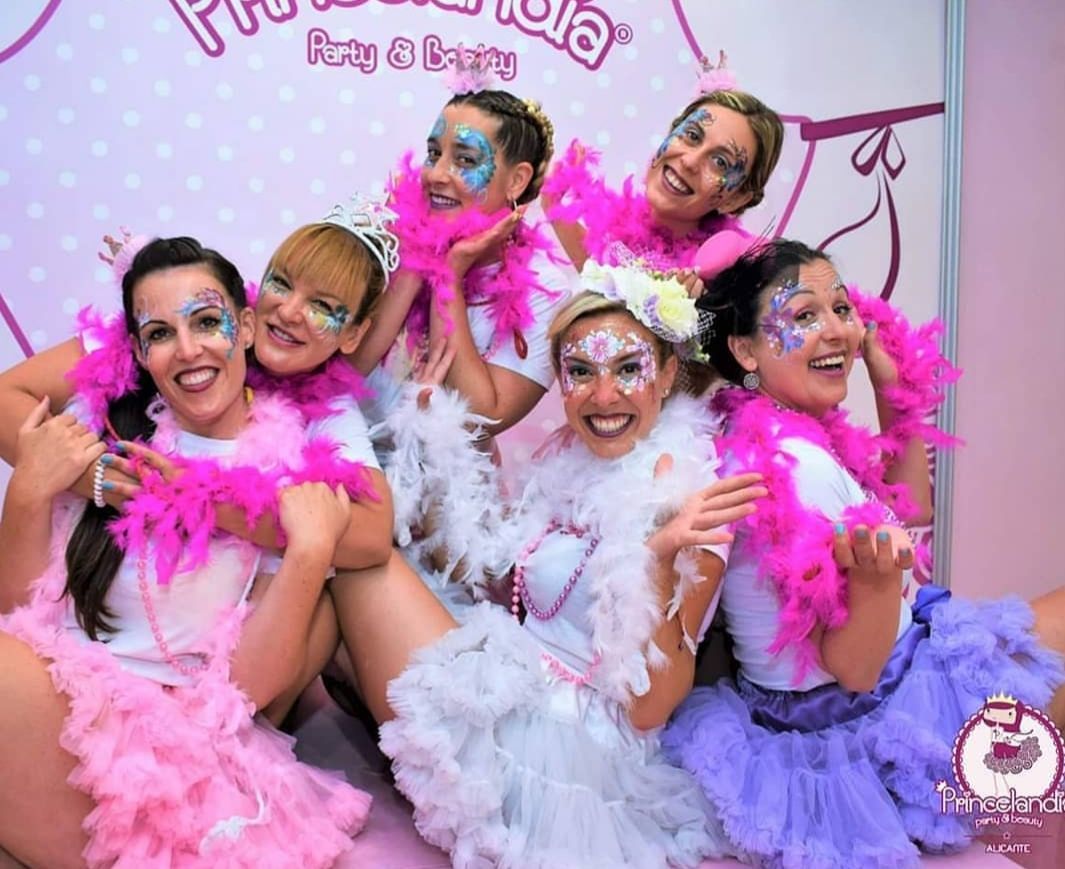 Un grupo de mujeres posan para una fotografía con sus caras pintadas.