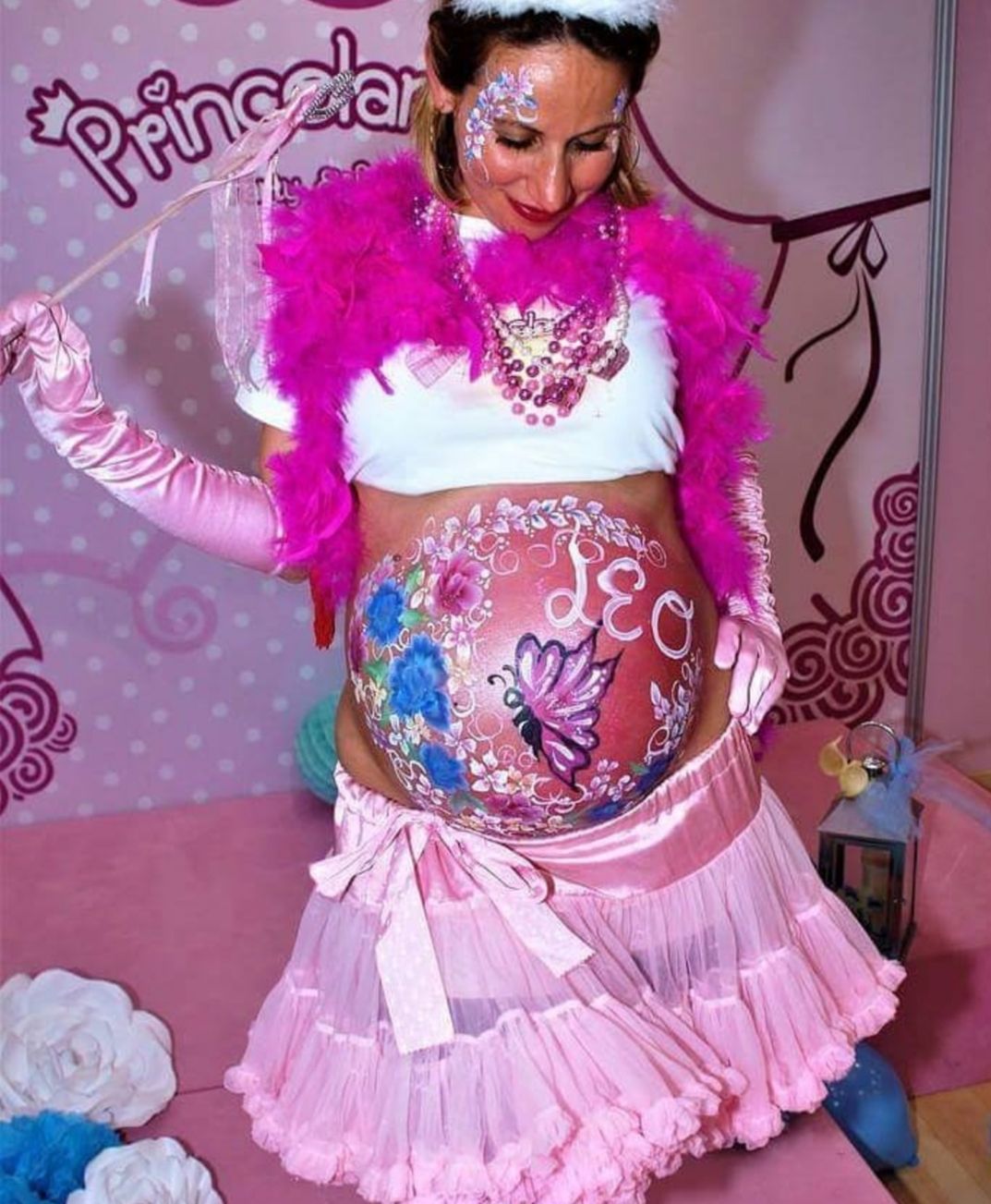 Una mujer embarazada tiene su vientre pintado como una princesa