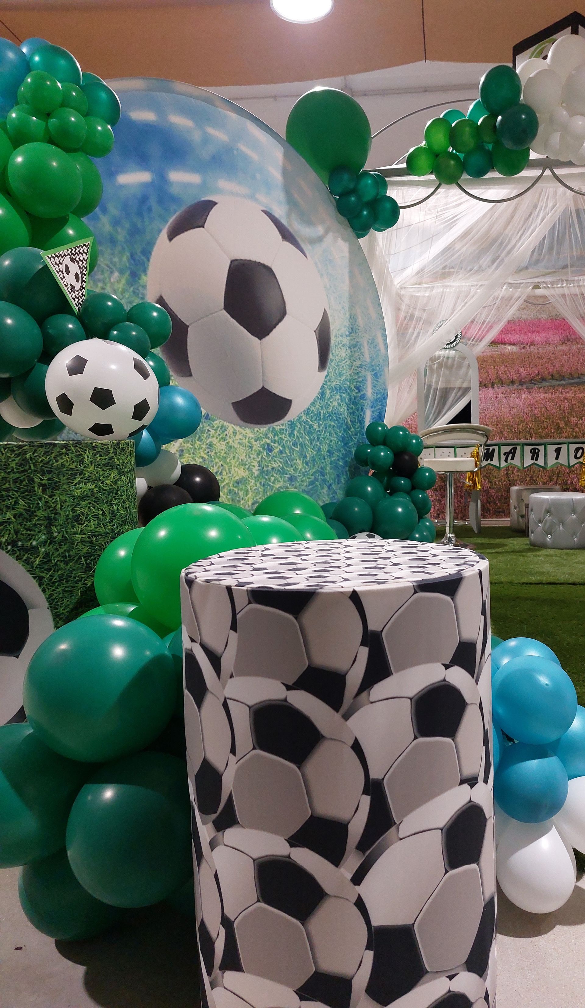 Una habitación decorada con globos y pelotas de fútbol para una fiesta de fútbol.
