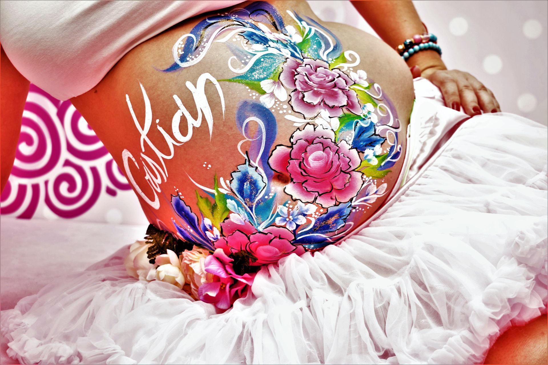 Una mujer embarazada con flores pintadas en su vientre.