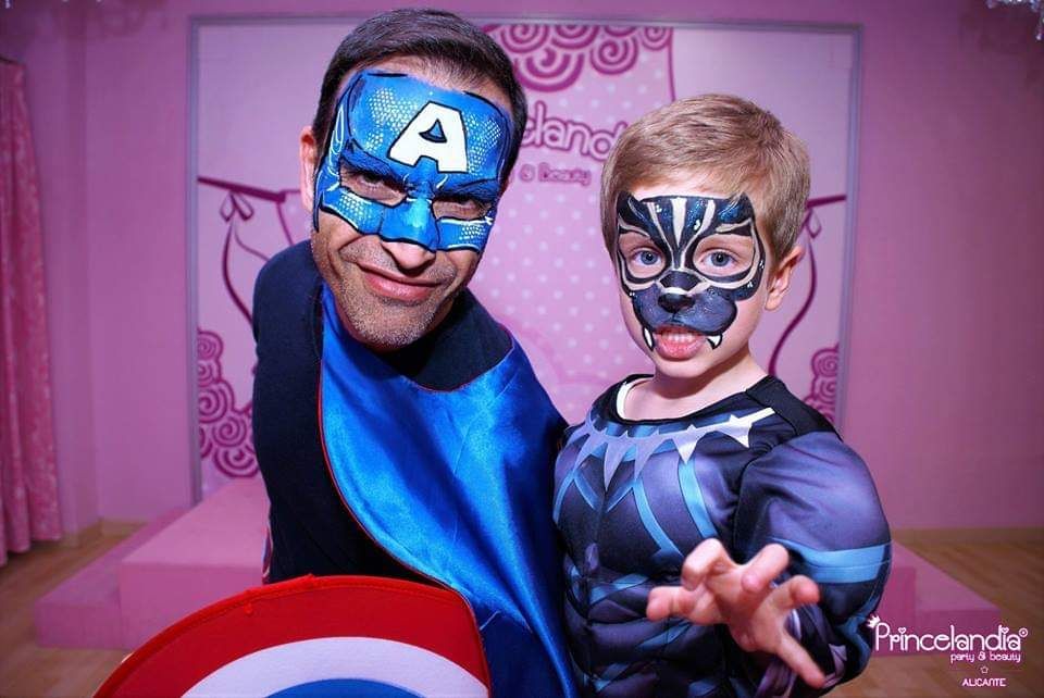 Un hombre y un niño con las caras pintadas posan para una fotografía.