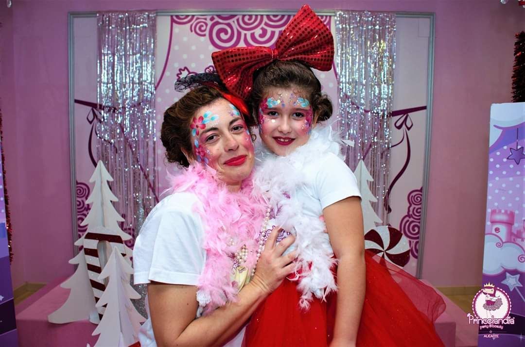 Una mujer y una niña con la cara pintada posan para una fotografía.