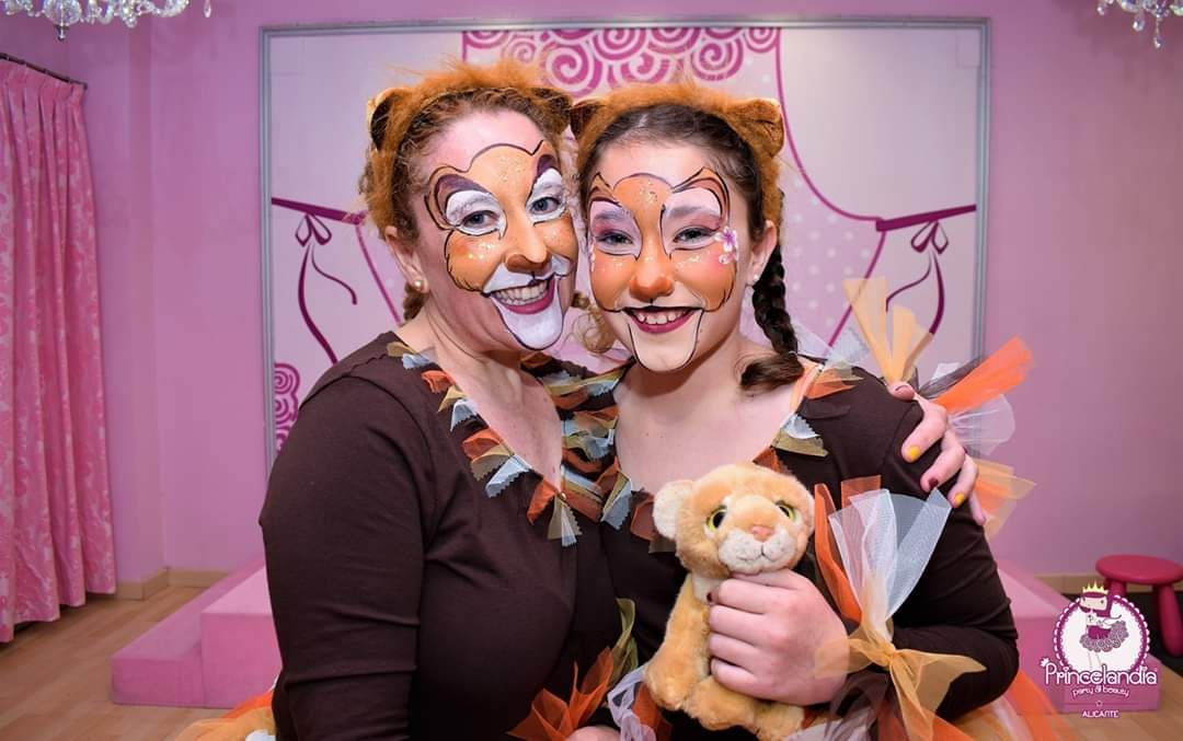 Dos mujeres con la cara pintada en la mano sostienen un animal de peluche.