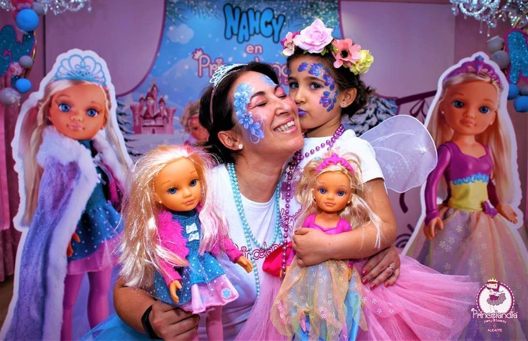 Una mujer y una niña posan para una foto con muñecas.