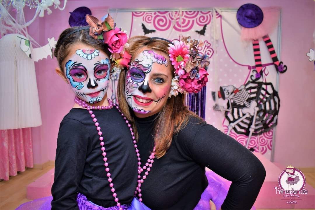 Una mujer y una niña posan para una foto con sus caras pintadas.