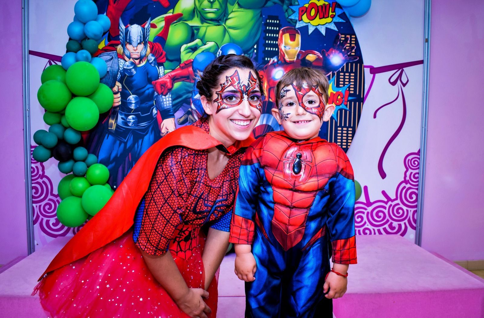 Una mujer y un niño disfrazados de superhéroes posan para una fotografía.