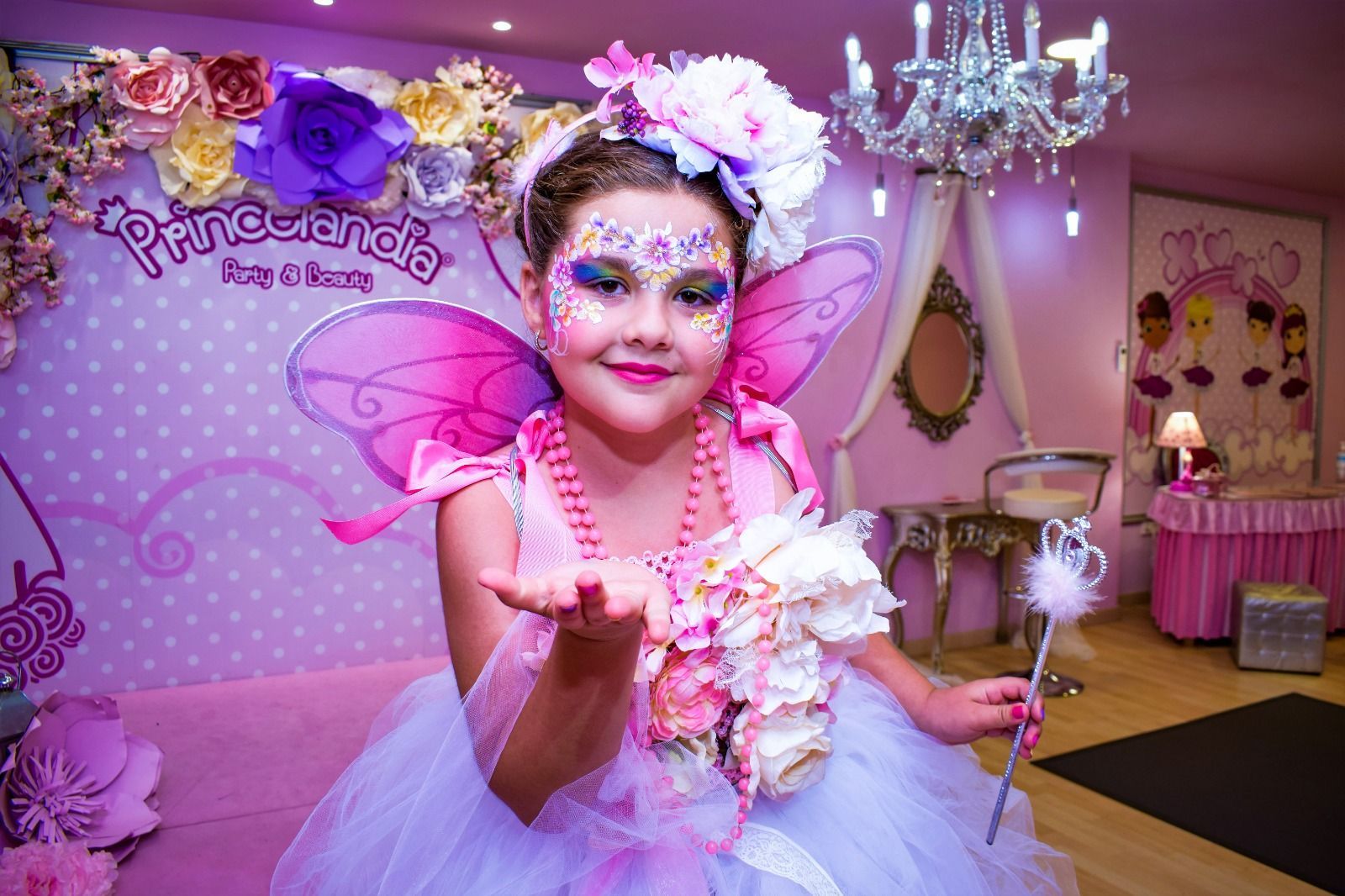 Una niña lleva un disfraz de hada y sostiene una varita.