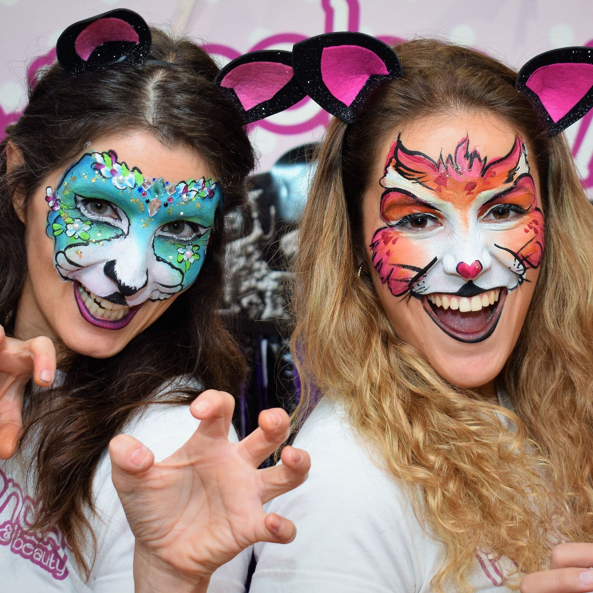Dos mujeres con sus caras pintadas para parecer gatos
