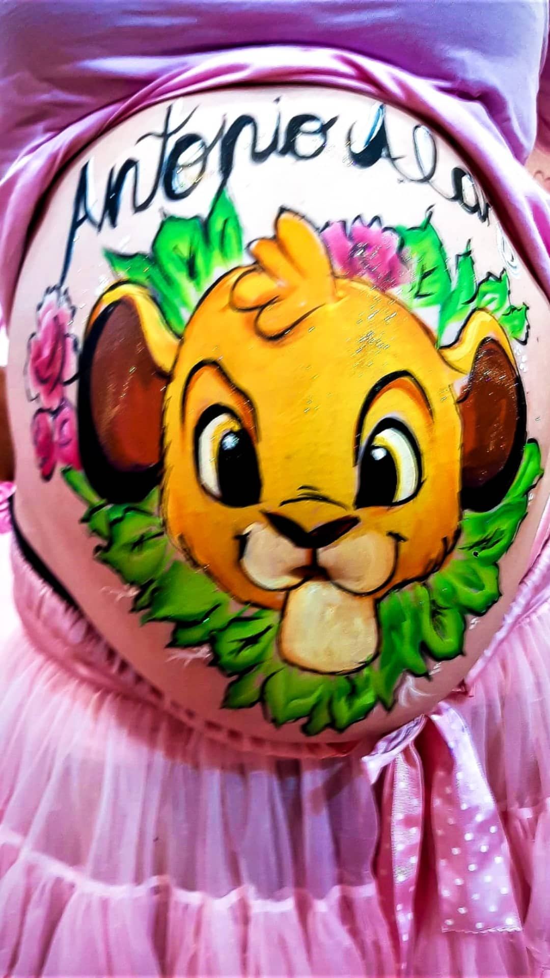 Una mujer embarazada tiene un cuadro del rey león en su vientre.