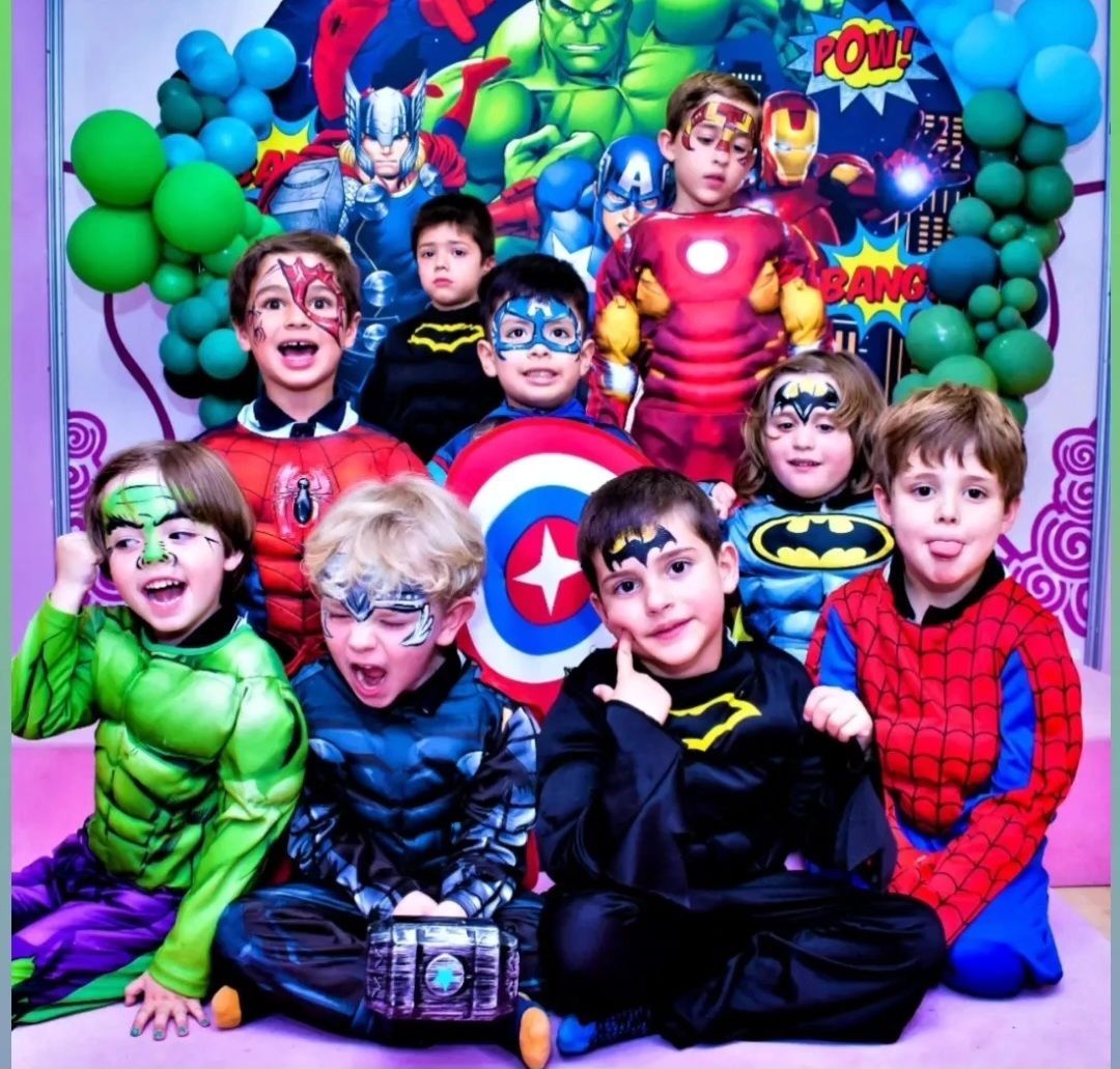 Un grupo de niños vestidos con disfraces de superhéroes posan para una foto.