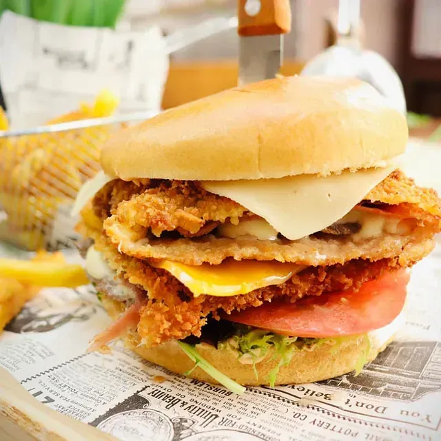 Un primer plano de un sándwich de pollo en un periódico.